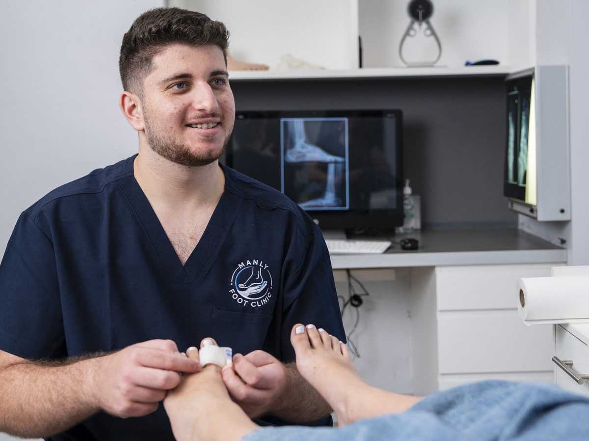 A podiatrist dressing a patient’s toe at Manly Foot Clinic